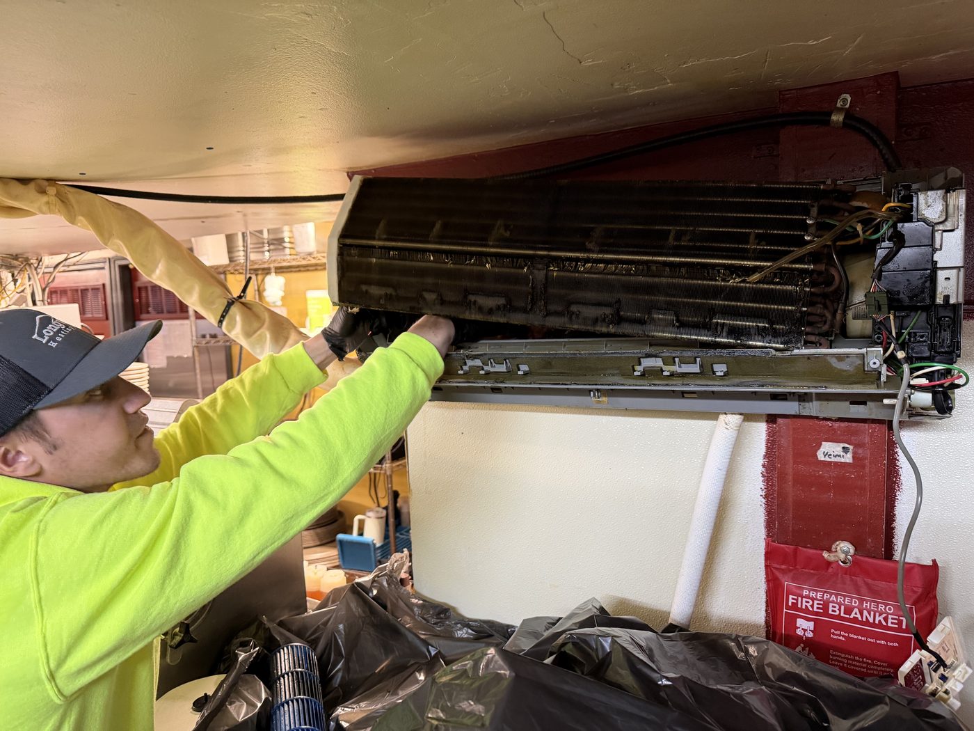Longview technician deep-cleaning a ductless mini-split indoor coil in a commercial kitchen